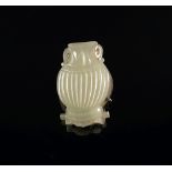 A Chinese carved pale green jade and silver mounted vase form badge,