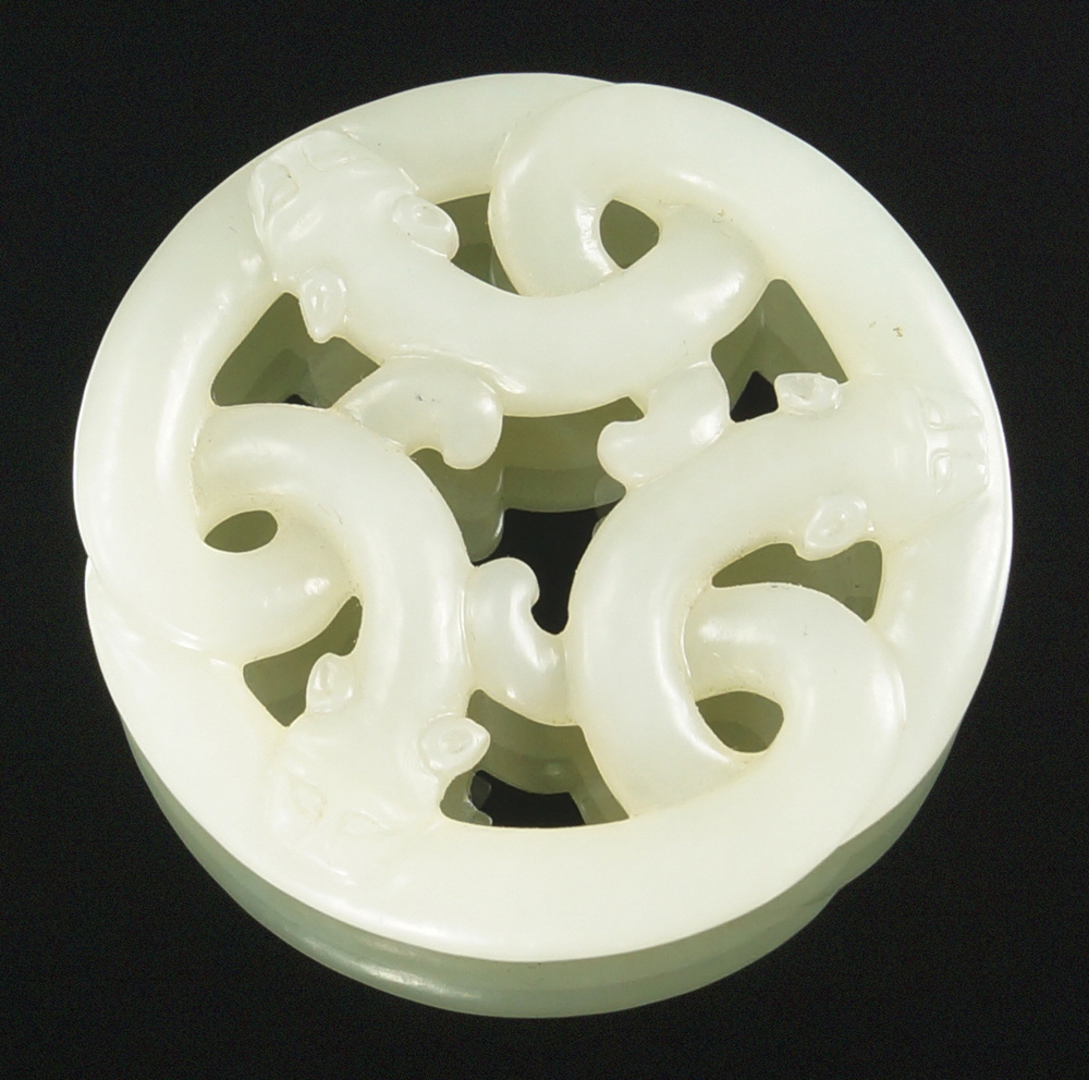 A Chinese carved pale green jade three dragon circular plaque, of pierced and circular form,