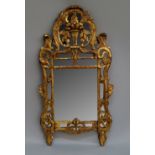 A Spanish or Italian giltwood mirror, 19th century, the frame of pierced form with a central vase of