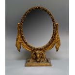 An Italian or Spanish giltwood swing frame mirror, late 19th/20th century, the oval framed moulded