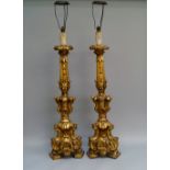A pair of Italian or Spanish giltwood alter candlesticks, 20th century, overall carved with