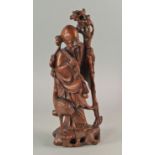 A Chinese hardwood carving of a sage, late 19th/20th century, holding a staff with a crane to his