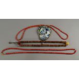 Two coral necklaces, 20th century, one hung with a glass plaque framed in a  metal surround,