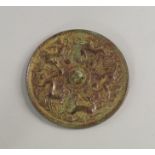 A Chinese bronze circular mirror, moulded with continuous bands of kylins chasing grapes,