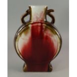 A Chinese porcelain moon flask, 20th century, with twin handles, overall with flambe red glaze,