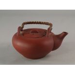 A Chinese yixing tea pot, 19th/20th century, with rattan handle and lid, 7cm high CONDITION