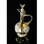 An Art Nouveau pewter mounted liqueur decanter and stopper, c.1900, of sinuous foliate form,