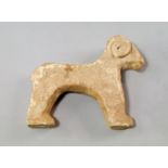 A Bactrian style terracotta model of a goat, modelled in the round, having stylised spiral horns and