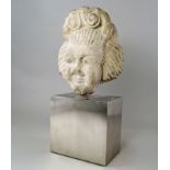 An Eastern carved grey stone janiform head, possibly ancient, each face carved with twin scroll