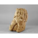 A Gandhara style carved stone lion, carved in deep relief with stylised face and two front legs,