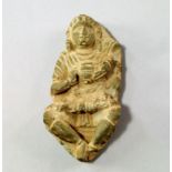 A Gandharan style carved schist model of a nobleman, carved in deep relief, wearing flowing robes