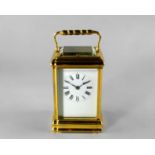 A large brass carriage clock, 20th century, with knopped faceted carrying handle, the white enamel