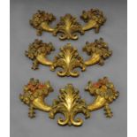 A set of three Continental carved gilt wood wall sconces in the form of cornucopiae emanating from