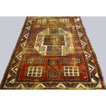 An antique Kazak rug with central ivory octagon and star filled square corner panels,