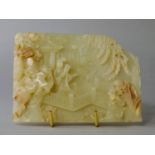 A Chinese pale green jade rectangular plaque, early 20th century, carved in deep relief with a woman