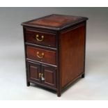 A Chinese hardwood bedside chest, 20th century, with two drawers above pair of cupboard doors, on