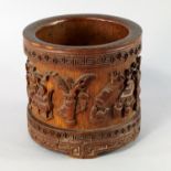 A Chinese bamboo brush pot, bitong, 19th century, carved in relief with various scholarly objects