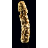 A Japanese ivory tusk tip okimono, Meiji period, carved with three figures, a Buddhist lion and a