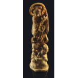 A Japanese Meiji period ivory okimono, carved as a female saint standing on a Buddhist lion,