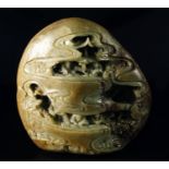 A large Chinese pale green jade boulder, 20th century, carved to both sides with figures and