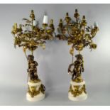 A pair of French Louis XVI style bronze and white marble seven light candelabra, late 19th/early