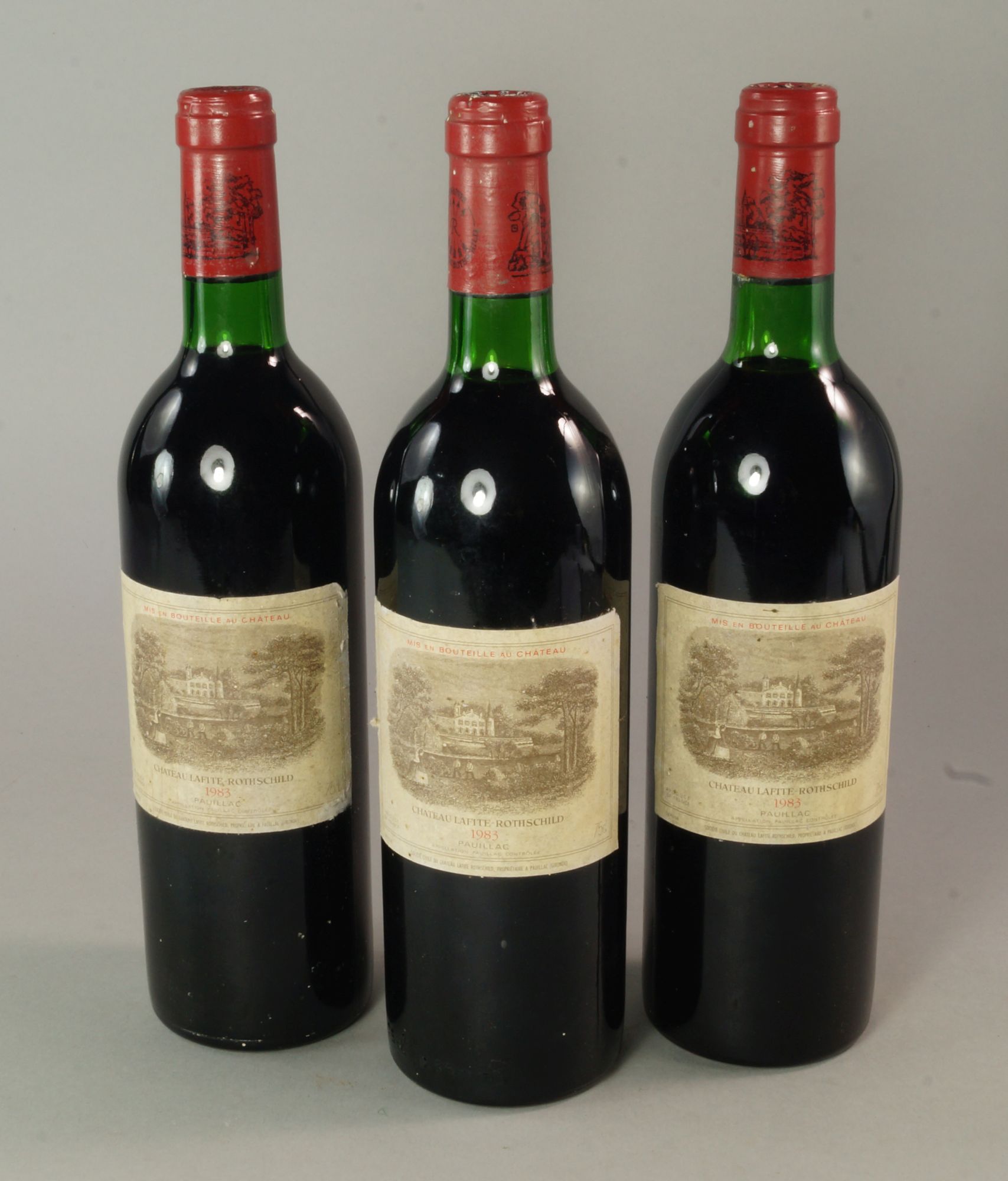 Three bottles of Chateau Lafite Rothschild 1983, ullages to top of shoulder,