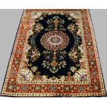 A Tabriz silk rug with pole medallion in an indigo field, with red main border,