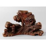A Chinese bamboo brush rest, late 19th/20th century, carved with a scholar in a rocky landscape with