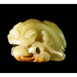 A Chinese dark green jade toad carving, 20th century, the toad holding a pomegranate in its mouth,