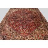 A Heriz carpet with indigo and ivory pole medallion in a deep red field,