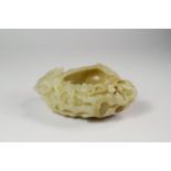 A Chinese pale green jade peach-form brushwasher, late 19th/ early 20th century, finely carved