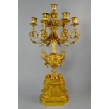 A French gilt bronze seven light candelabra, late 19th century, the base of urn form with square