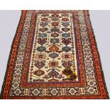 A Caucasian rug with repeat design of shaped medallions in an ivory field and with multiple border,