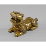 A Chinese bronze Warring States style lion, modelled recumbent with gem set eyes and inlaid gilt and