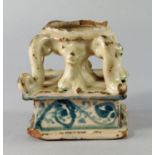 An Italian maiolica salt, probably 17th century, of urn form with mask leg feet and scrolling