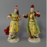 A pair of French porcelain models of a a Turk and his wife, 20th century, he modelled wearing a