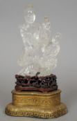 A Chinese rock crystal figural group
Formed as Guanyin and an attendant, mounted on a carved and