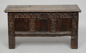 An 18th century oak coffer
The hinged rectangular top above the panelled front with scroll carved