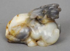 A Chinese carved jade type buffalo
In recumbent pose.  6 cm high. CONDITION REPORTS: Generally in