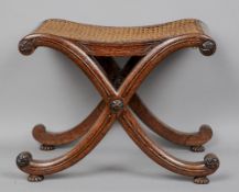 An early 19th century oak X-framed stool