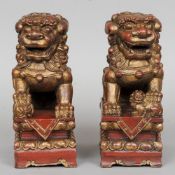 A pair of Chinese carved giltwood and red lacquered temple dogs
Both worked in typical pose,