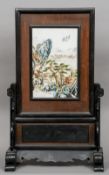 A Chinese hardwood framed painted porcelain table screen
Decorated with figures and a village in a