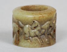 A Chinese carved jade archers ring
Of typical form, the exterior carved with a band of horses.  3 cm