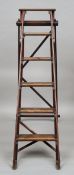 A set of stained pine folding steps
Each rung with an applied brass plate.  155 cm high. CONDITION
