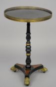 A 19th century brass mounted ebonised tripod table
The circular top with a pierced brass gallery