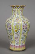A Chinese famille rose porcelain vase
Of reeded form, decorated with bands of foliage, the underside