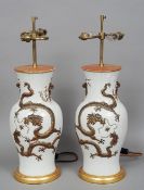 A pair of Chinese porcelain vases
Each with applied dragons, chasing a flaming pearl, adapted as