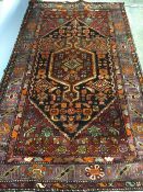 A Hamadan wool rug
The midnight blue field enclosing a central pole medallion with geometric motifs,