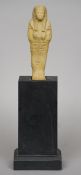 An Egyptian shabti figure
Of typical form, mounted on a later wooden display stand.  The figure 15.5