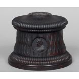 A 19th century Continental carved hardwood box
Of cylindrical form, the gadrooned domed lid carved